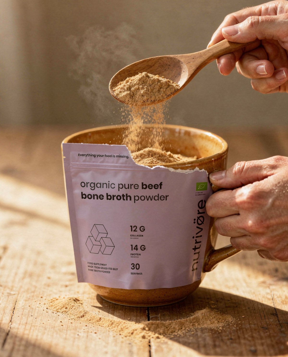Scooping Nutriōteca Bone Broth powder into a warm mug